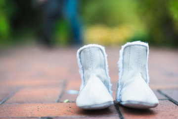 children's shoes on the background of a man and a pregnant woman