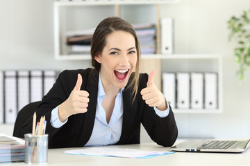 Excited executive looking at camera with thumbs up