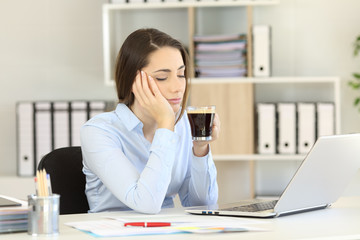 Somnolent executive drinking coffee at office