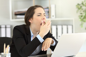 Tired executive yawning at office