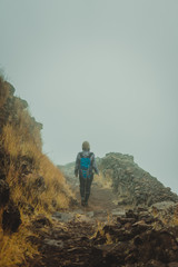 Woman hiker on the cobbled misty path on the mountain crest on Santo Antao island, Cape Verde