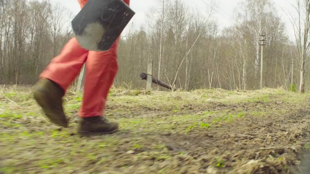 Legs of the woman moving on the dirty road in a spring forest. The scientist ecologist going to the place of research.