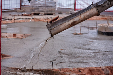 building construction  pouring cement or concrete with pump tube from concrete mixer truck car.