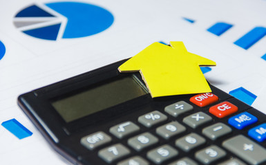 Mortgage Loans Concept with Paper House and Calculator on White Background with Diagram.