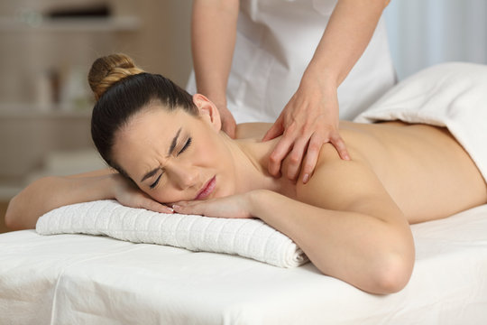 Woman suffering receiving a massage
