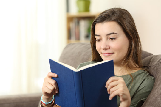 Teen Reading A Paper Book On A Sofa