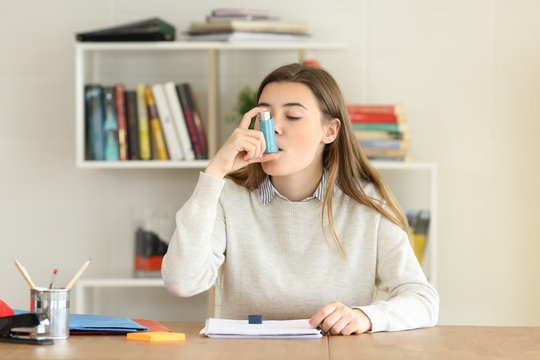 Student Using An Asthma Inhaler At Home