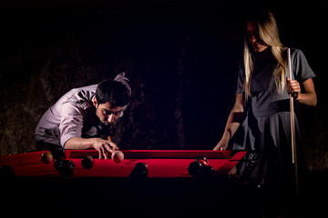 Young romantic couple playing billiard game