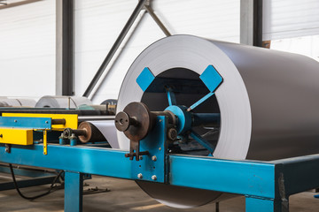 Roll of galvanized steel or metal on machine in industrial workshop on rolling mill, manufacturing metalwork factory