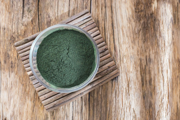 seaweed powder spirulina on wooden background