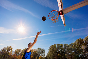Slam Dunk. Side view of young basketball player making slam dunk