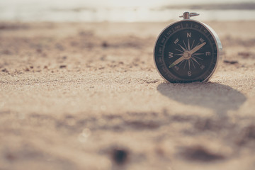 Compass is placed on the beach and sunshine in the evening sunset