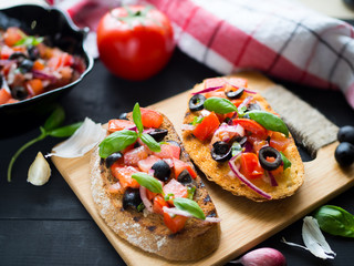 Bruschetta with Tomato and Basil on black wooden boards.