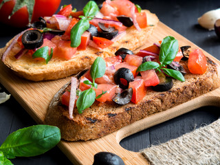 Bruschetta with Tomato and Basil on black wooden boards.