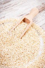 Quinoa seeds containing natural minerals and vitamins on rustic board, concept of healthy nutrition
