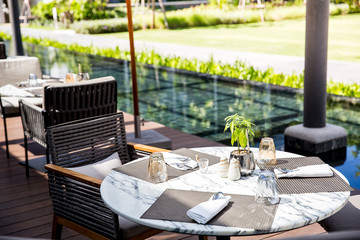 round marble stone table in the outdoor restaurant with preset cutlery