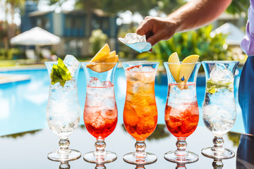 Bartender makes craft cocktails near the pool. Vacation, summer, holiday, luxury resort concept