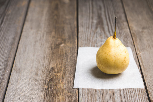 Fresh ripe pear on the wooden background. Selective focus.