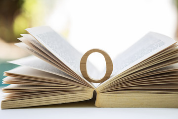 Wooden ring on old book over blurred background