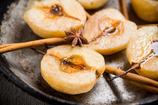 Grilled pears with cinnamon and honey on the rustic background. Selective focus.