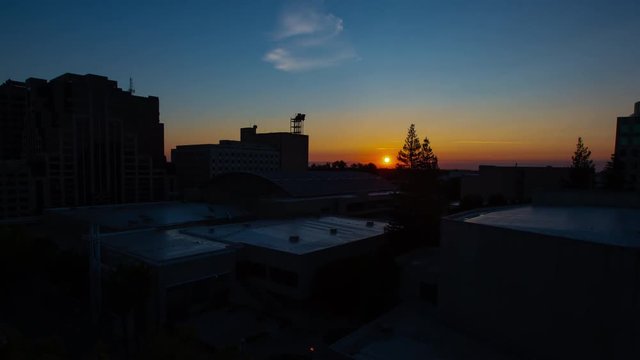 Sunrise time lapse over convention center with zoom in Sacramento, California