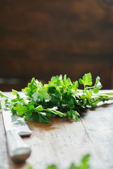 Bunch chopped parsley large knife wooden table close up
