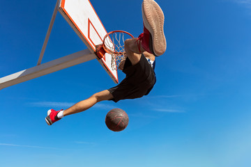 Slam Dunk. Side view of young basketball player making slam dunk