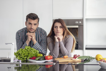 Portrait of happy young couple cooking together in the kitchen at home.