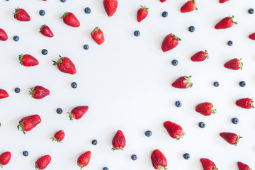 Fruit pattern. Strawberry and blueberry on blue background. Flat lay, top view, copy space