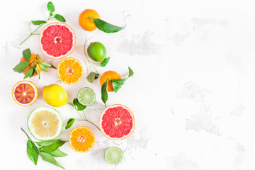 Fruit background. Colorful fresh fruits on white table. Orange, tangerine, lime, lemon, grapefruit. Flat lay, top view, copy space