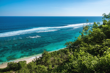 Tropical sandy beach and clear ocean with blue water in Bali
