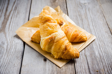 Fresh croissants on the wooden background. Selective focus.