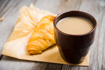 Cup of coffe with cake on thw rustic wooden background. Selective focus.