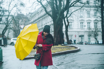 woman cover with yellow umbrella in windy weather. storm alarm.