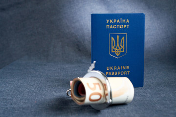 Ukrainian biometric passport and handcuffs on the table.