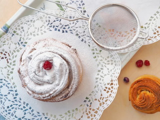 Homemade cruffin dessert decorated with sugar powder and dried cranberries. Close up, top view....