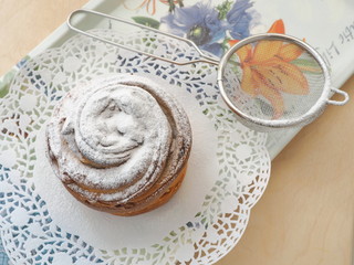 Fresh pastry decorated with sugar powder. Cruffin or muffin. Close up, top view. Selective focus.