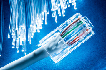 Network cable and optical fibers with lights in the ends at the background.