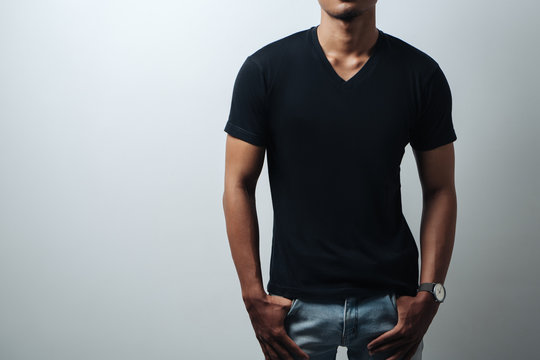 man in black blank t-shirt, empty wall, studio close-up