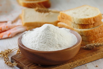 Fototapeta na wymiar Flour in bowl with grain ears
