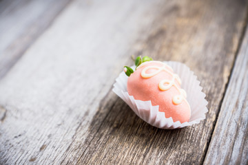 Ripe strawberry with chocolate glaze on the wooden background. Selective focus.