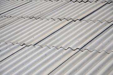 A fragment of a gray slate roof of an old sample made of asbestos material