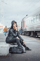 Obraz na płótnie Canvas Woman in black dress on the railroad station