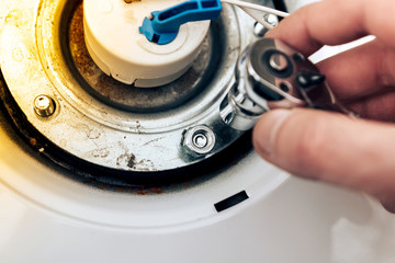 repair of boilers, the hand of the master throws and twists the nuts, close-up
