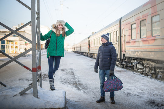 Couple at railway station near train in a winter time
