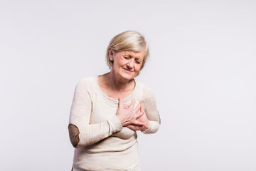 Studio portrait of a senior woman in pain.