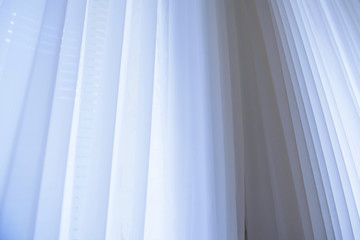 Obraz premium White cloth curtains on window. The texture of the fabric hanging down. 
