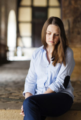 Young beautiful woman sitting miserable on the stairs