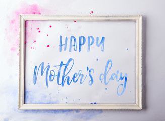 Happy mothers day composition. A text in a wooden frame on white background. Studio shot.