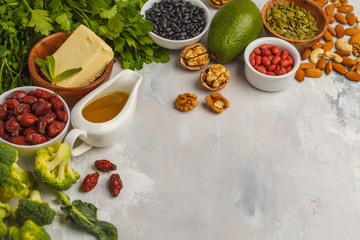 Healthy food nutrition dieting concept. Assortment of high vitamin E sources. Oil, nuts, avocado, butter, healthy fats, rose hips, parsley, seeds, spinach. White backgdound, copy space